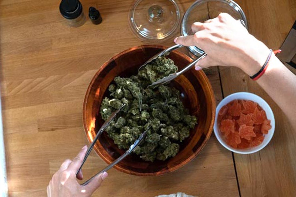 Tossing cannabis in a bowl with tongs 