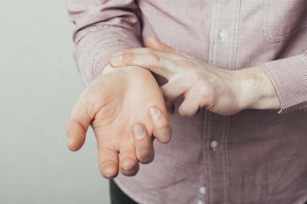 A person checks their own pulse